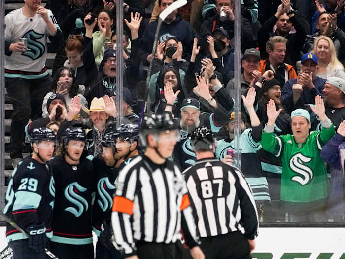 Seattle Kraken fans pound the glass as they celebrate a goal by right wing Jordan Eberle against the Arizona Coyotes.